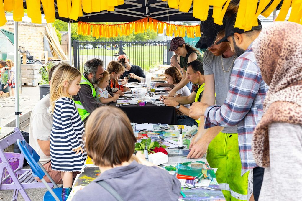Families outside gathererd around a table doing arts activities under an awning